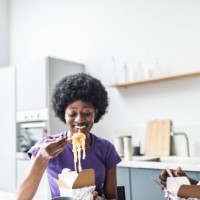 young adult black couple eating take out wok - junk food stock pictures, royalty-free photos & images