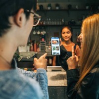 young adults browsing digital menu on mobile app while ordering at cafe - junk food stock pictures, royalty-free photos & images