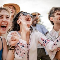 young adults celebrate joyfully at an outdoor music festival during sunset with lively dancing and excitement - concert stock pictures, royalty-free photos & images