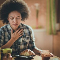 young african american woman feeling nausea during breakfast time at dining room. - food stock pictures, royalty-free photos & images