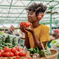 young african woman buying tomatoes at the market - food stock pictures, royalty-free photos & images
