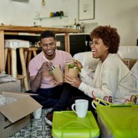 young afro-caribbean couple enjoying take-out on moving day - junk food stock pictures, royalty-free photos & images
