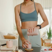 young asian athletic woman using blender and pouring smoothie to glass at home. healthy food. - food stock pictures, royalty-free photos & images