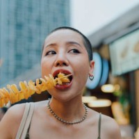 young asian couple tourist eating crispy potato chips at the street food. - food stock pictures, royalty-free photos & images
