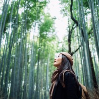 young asian female backpacker enjoying in nature. taking a deep breath of fresh air while having a relaxing walk in the bamboo forest in the countryside during the outbreak of coronavirus pandemic - travel photos et images de