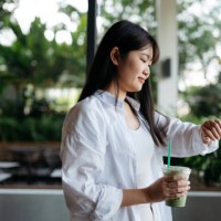 young asian female having matcha latte while checking time - junk food stock pictures, royalty-free photos & images