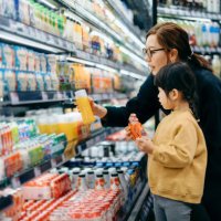 young asian mother and her little daughter grocery shopping in supermarket. they are choosing fresh fruit juice together along the beverage aisle. routine grocery shopping. healthy eating lifestyle - food stock pictures, roya