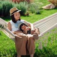 young asian mother and her little girl relaxing on hammock in the garden - garden decoration photos et images de collection