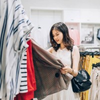 young asian woman choosing new clothes in the clothing store. - fashion stock pictures, royalty-free photos & images