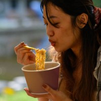 young asian woman eating instant noodles morning - junk food stock pictures, royalty-free photos & images