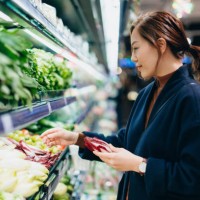 young asian woman grocery shopping in supermarket, choosing fresh organic fruits and vegetables along the produce aisle. fruits and vegetables shopping. routine shopping. zero waste. healthy eating diet and go green lifestyle