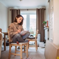 young asian woman moved into her new house and checking the list of new flat pack furniture - home decoration stock pictures, royalty-free photos & images