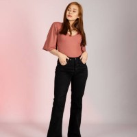young asian woman posing in a studio shot with her hands in her pants pocket looking away - fashion stock pictures, royalty-free photos & images