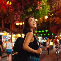 young asian woman with backpack walking at night market during chinese new year - travel stock-fotos und bilder