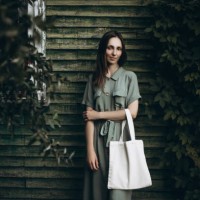 young beautiful woman in a green dress with a white eco bag - fashion stock-fotos und bilder