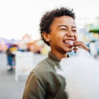 young boy with braces eating candy floss at fair - food stock pictures, royalty-free photos & images