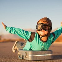 young boy with goggles imagines flying on suitcase - travel stock pictures, royalty-free photos & images