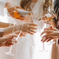 young bridesmaids clinking with glasses of champagne in hotel room. closeup photo of cheerful girls celebrating a bachelorette party. females have toast with wine - home decoration stock pictures, royalty-free photos & images