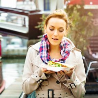 young british woman looks at take-out food with appetite - junk food stock pictures, royalty-free photos & images