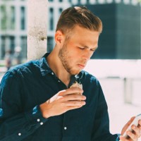young businessman having lunch outside while looking at his cell phone - junk food stock pictures, royalty-free photos & images
