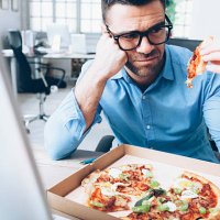 young businessman having unpleasent pizza lunch break at workplace - junk food stock pictures, royalty-free photos & images