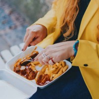 young businesswoman eating french fries at public park - junk food stock pictures, royalty-free photos & images