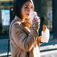 young businesswoman having coffee and croissant on the street - junk food stock pictures, royalty-free photos & images