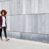 young businesswoman walking on sidewalk by wall - fashion stock pictures, royalty-free photos & images