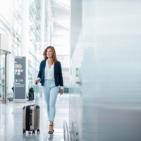 young businesswoman walking with luggage at the airport - travel stock pictures, royalty-free photos & images