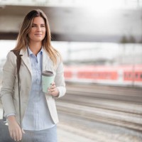 young businesswoman with coffee to go cup, standing on station - junk food stock pictures, royalty-free photos & images