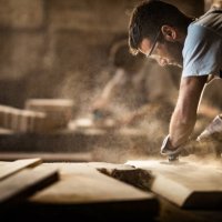 young carpenter using sander while working on a piece of wood. - home decoration stock pictures, royalty-free photos & images