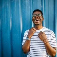 young, cheerful black man on blue door background - fashion stock pictures, royalty-free photos & images
