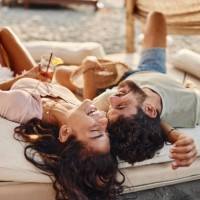 young cheerful couple having fun on a beach bed. - home decoration stock pictures, royalty-free photos & images