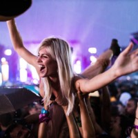 young cheerful woman held by her friends during rainy night on music festival. - concert stock pictures, royalty-free photos & images