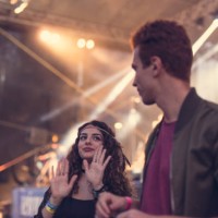 young couple dancing in front of the stage at music festival - concert stock pictures, royalty-free photos & images