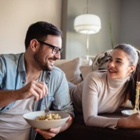 young couple eating noodles at home - junk food stock pictures, royalty-free photos & images