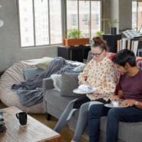 young couple eating take out food at home - junk food stock pictures, royalty-free photos & images