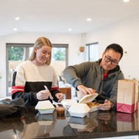 young couple enjoying delivery food at home - junk food stock pictures, royalty-free photos & images