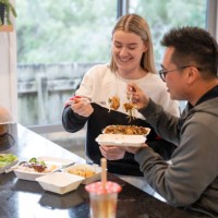 young couple enjoying takeaway food at home - junk food stock pictures, royalty-free photos & images