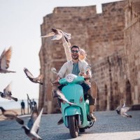 young couple having fun riding scooter in old european town - travel stock pictures, royalty-free photos & images