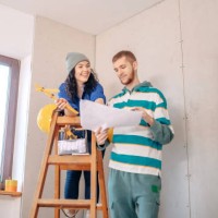 young couple in new home - home decoration stock pictures, royalty-free photos & images