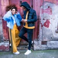 young couple listening to music through headphones on smartphone - fashion stock pictures, royalty-free photos & images
