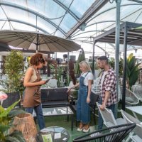 young couple looking for garden furniture happy looking at deckchairs and hammocks, afro clerk with tablet advice them - garden decoration stock pictures, royalty-free photos & images