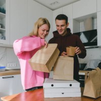 young couple man and woman ordered pizza delivery and asian food home - junk food stock pictures, royalty-free photos & images