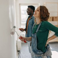 young couple painting walls - home decoration stock pictures, royalty-free photos & images