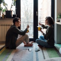 young couple with take out food siting by window at home - junk food stock pictures, royalty-free photos & images