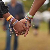 young couple with wristbands holding hands - concert stock pictures, royalty-free photos & images