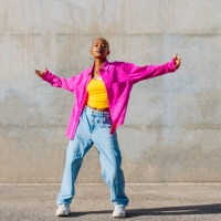 young dancer with arms outstretched in front of wall - fashion stock pictures, royalty-free photos & images