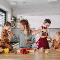 young family with two little children preparing breakfast together in kitchen. - food stock pictures, royalty-free photos & images