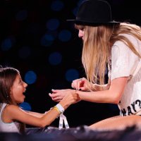 Young fan exchanges friendship bracelets with Taylor Swift as she performs onstage during "Taylor Swift | The Eras Tour" at Allianz Parque on...